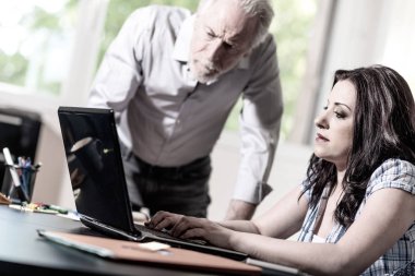 Genç iş kadını ve birlikte ofiste çalışan üst düzey iş adamı