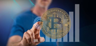 Bir adam dokunmatik ekranda bitcoin para kavramına parmağıyla dokunuyor