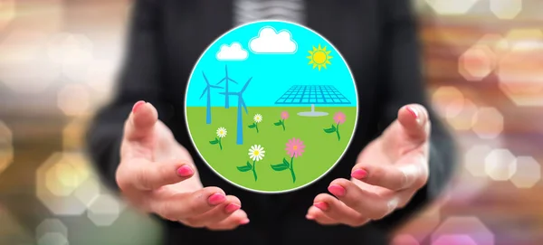 Clean energy concept above the hands of a woman in background