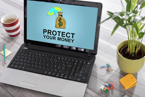 Laptop on a desk with money protection concept on the screen
