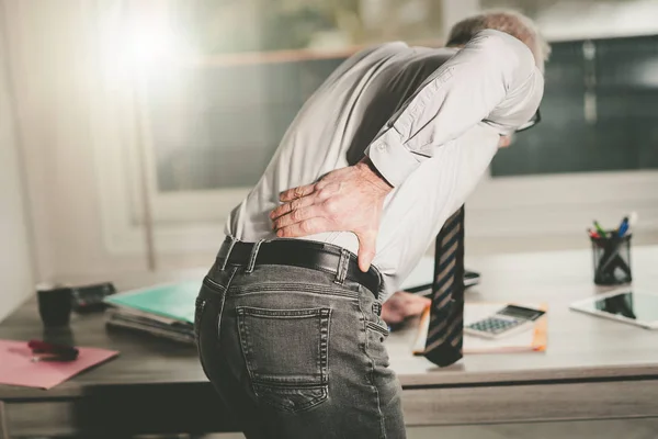 Uomo d'affari che soffre di mal di schiena, effetto luce — Foto Stock