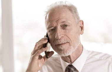 cep telefonu üzerinde konuşurken üst düzey iş adamı