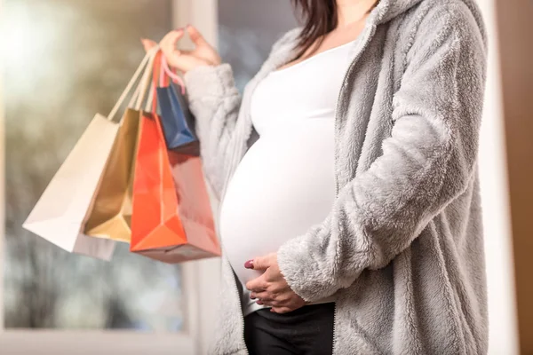 Kobieta w ciąży z torby na zakupy dotykając jej brzuch — Zdjęcie stockowe