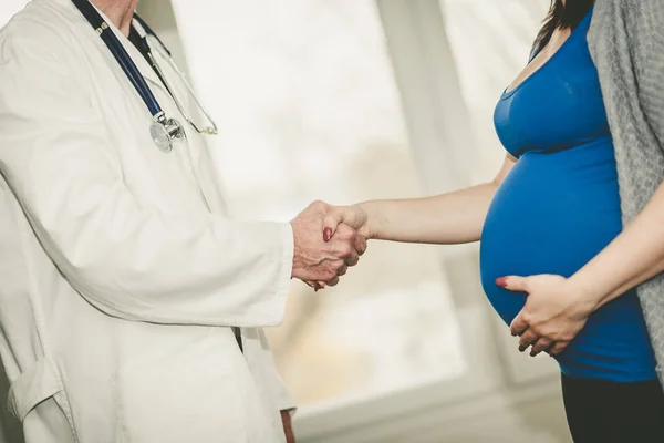 Рукостискання між вагітною жінкою і лікарем — стокове фото