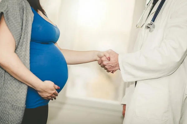 Рукостискання між вагітною жінкою і лікарем — стокове фото