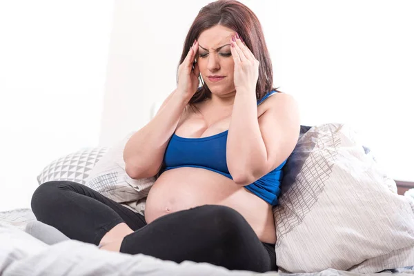 Těhotná žena trpí bolestmi hlavy — Stock fotografie