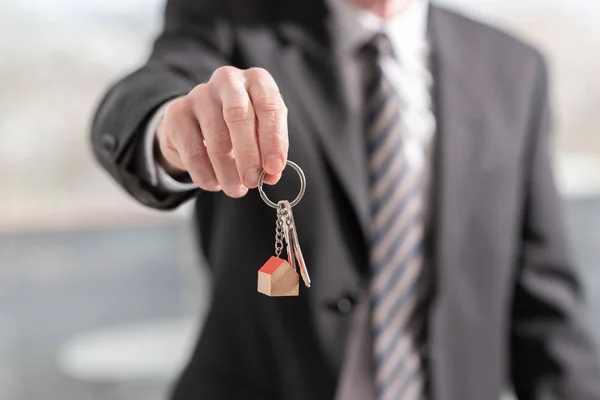 Агент по недвижимости предлагает ключи от дома — стоковое фото