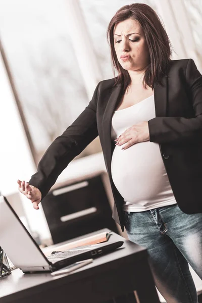Vyčerpaná těhotná žena před její laptop — Stock fotografie