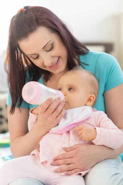 Mãe alimentando bebê menina com mamadeira — Fotografia de Stock