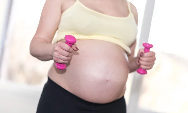 Těhotná žena školení s činkami — Stock fotografie