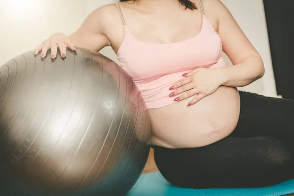 Terhes nő, ült a fitness labdát, fényhatás — Stock Fotó