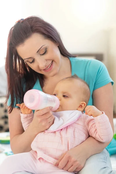 Madre alimentación bebé niña con biberón —  Fotos de Stock