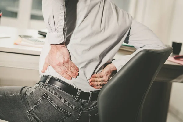 Businessman suffering from back pain, light effect — Stock Photo, Image