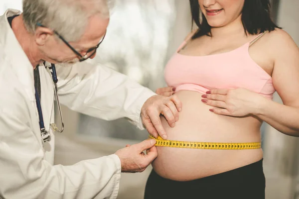 Лікар вимірює розмір живота вагітної жінки — стокове фото
