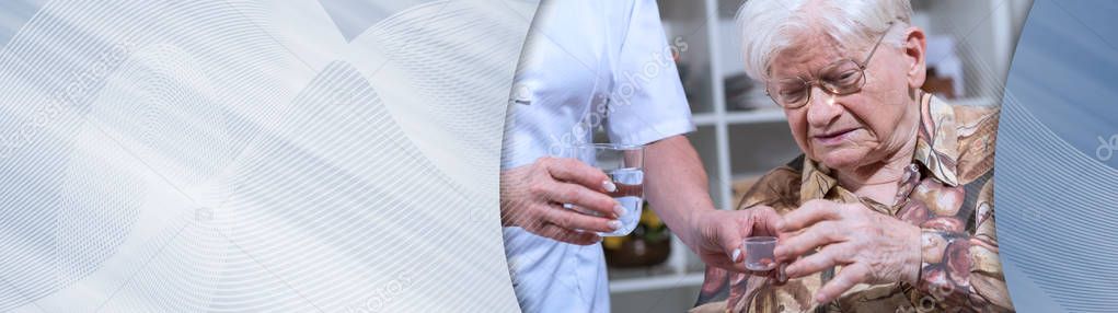 Nurse giving medication to a senior woman. panoramic banner