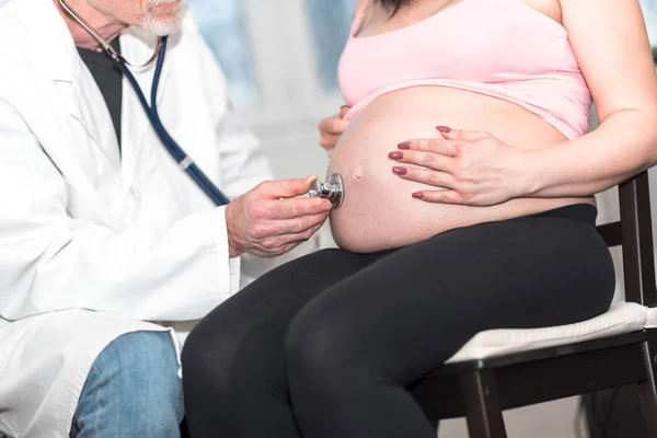 Лікар вивчає вагітну жінку зі стетоскопом — стокове фото