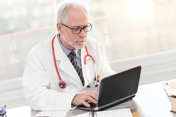 Medico anziano che utilizza laptop — Foto Stock