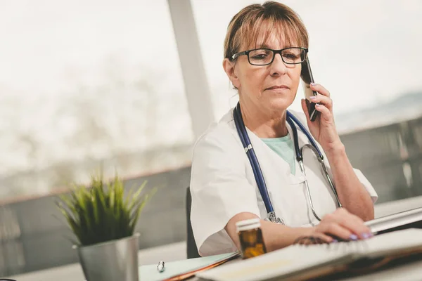 Vrouwelijke arts praten op mobiele telefoon — Stockfoto