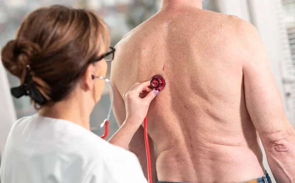 Médico usando estetoscópio para examinar o paciente — Fotografia de Stock