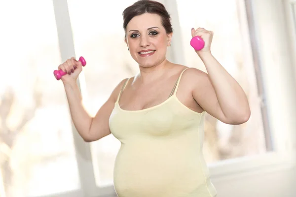 Mulher grávida treinando com halteres — Fotografia de Stock