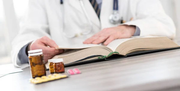 Doctor reading a textbook — Stock Photo, Image