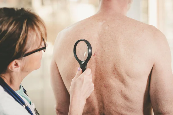 Dermatologe untersucht die Haut eines Patienten — Stockfoto
