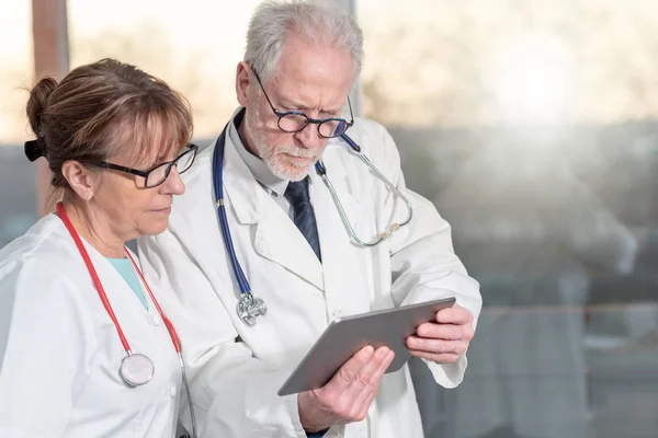 Dois médicos discutindo sobre o relatório médico no tablet — Fotografia de Stock