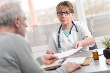 Kadın doktor hastasını için reçete verilmesi