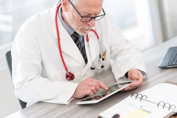 Mužský starší lékař používající digitální tablet — Stock fotografie
