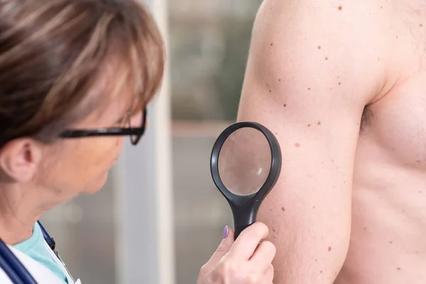 Dermatólogo examinando la piel de un paciente — Foto de Stock
