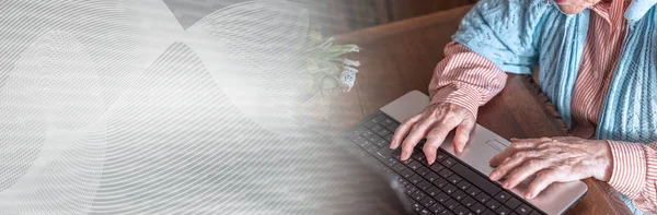 Old woman using a laptop; panoramic banner