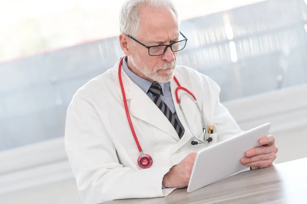 Medico senior di sesso maschile con tablet digitale — Foto Stock