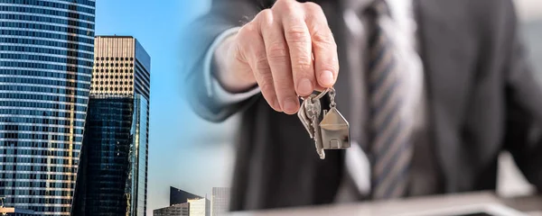 Immobilienmakler bietet Hausschlüssel an; Mehrfachbelichtung — Stockfoto