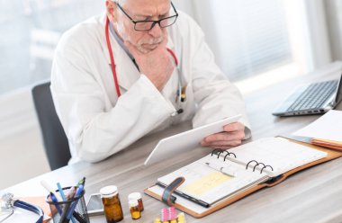 Dijital tablet kullanan erkek kıdemli doktor