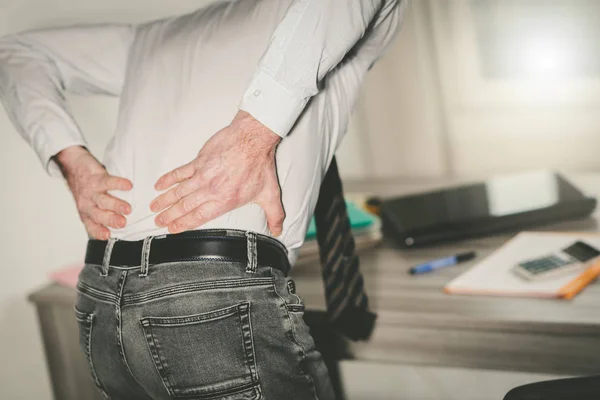 Businessman suffering from back pain, light effect — Stock Photo, Image