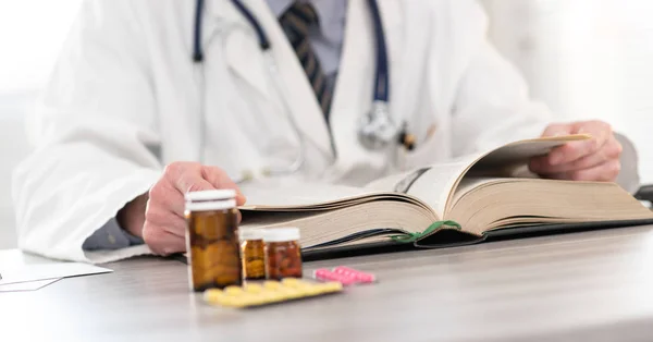 Doctor reading a textbook — Stock Photo, Image