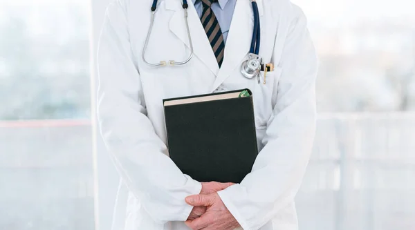 Doctor sosteniendo un libro médico — Foto de Stock