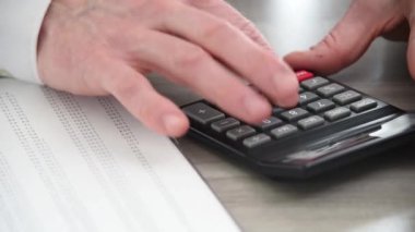 Hesap makinesi kullanan işadamının eli, yakın çekim
