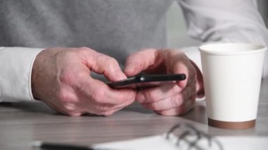 Akıllı telefonda yazan erkek eller.