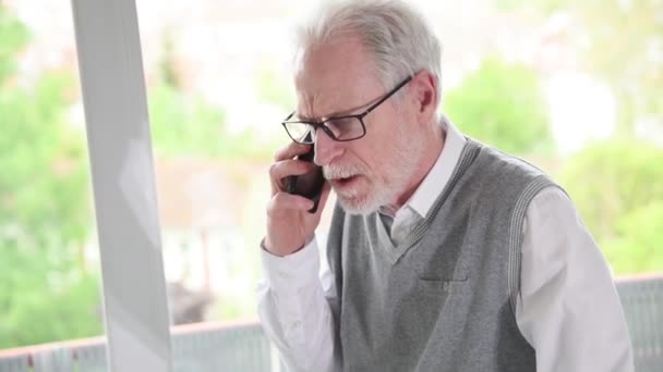 Senior zakenman praten op mobiele telefoon — Stockvideo