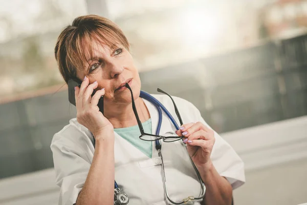 Médica feminina falando no celular — Fotografia de Stock