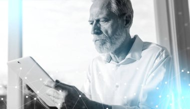 Üst düzey işadamı kullanarak bir dijital tablet, sert ışık