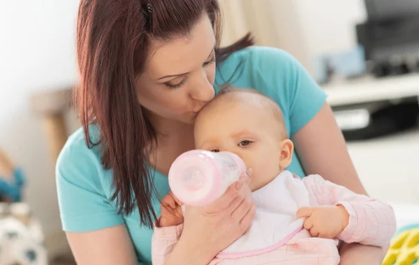 Mãe alimentando bebê menina com mamadeira — Fotografia de Stock