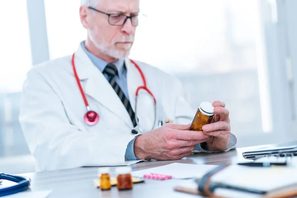 Läkare tittar på en flaska piller — Stockfoto