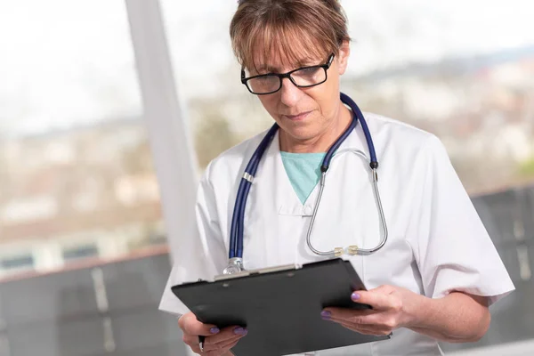 Médica feminina tomando notas na área de transferência — Fotografia de Stock