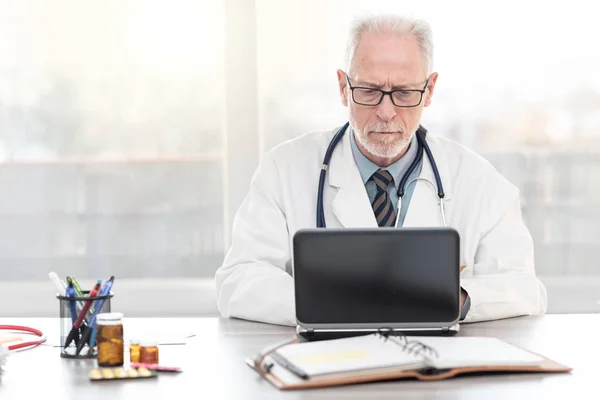 Medico anziano che utilizza laptop — Foto Stock