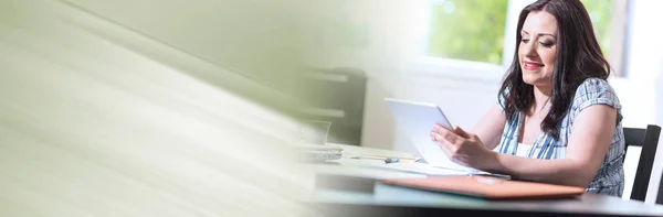 Jovem empresária atraente usando um tablet, efeito de luz; pan — Fotografia de Stock