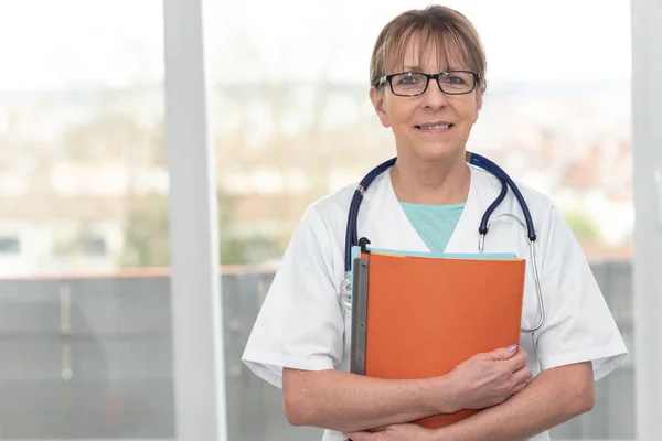 Portrait du médecin debout et tenant un dossier — Photo