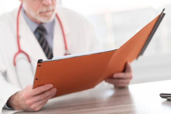 Arzt liest einen medizinischen Bericht — Stockfoto