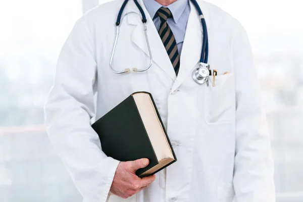 Doctor holding a medical textbook — Stock Photo, Image